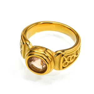 Detail of vintage gold titanium ring with a faceted round brown gemstone and ornate carvings