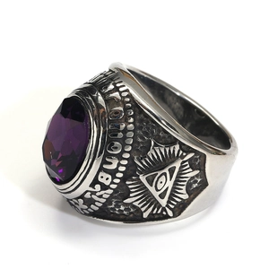 Detalle de anillo punk con piedra facetada púrpura y grabado del ojo de la providencia