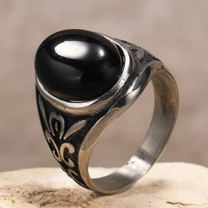 Dettaglio macro di anello punk da uomo con pietra nera ovale e decorazioni a rilievo
