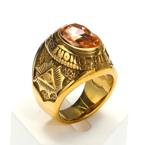 Detalle del Ojo de la Providencia en un anillo punk dorado con gema naranja central