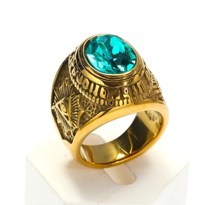 Macro de un anillo dorado con gema verde y grabado del Ojo de la Providencia