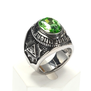 Vista macro de anillo punk con gema verde y detalle del ojo que todo lo ve
