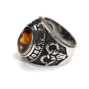 Detalle macro de anillo punk con piedra ámbar y banda de acero con grabados vintage
