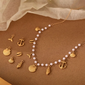 Goldene Perlenkette mit Meeresmotiven wie Anker, Muschel und Fischschwanz Anhängern