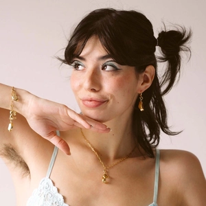 Close-up of golden irregular sunburst jewelry set with necklace and earrings on model
