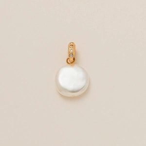 Detailed macro view of a coin-shaped white pearl pendant with a gold diamond-set clasp