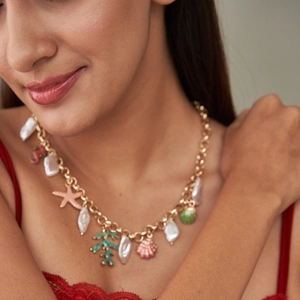 Golden ocean themed necklace with colorful starfish, shells and baroque pearls on model
