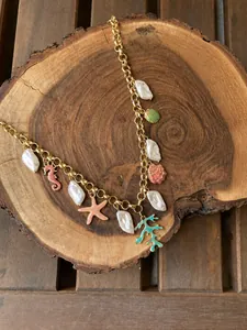 Detail view of gold-plated ocean charm necklace with colorful shells and starfish charms
