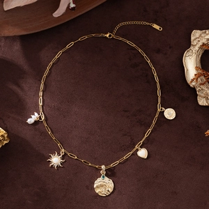 Gold paperclip chain necklace featuring opal heart, evil eye coin, and pearl charms