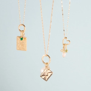 Close-up of gold zodiac Scorpio pendant with pearls and colorful gemstone charms