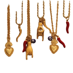 Colliers dorés avec pendentifs œil bleu, piment rouge et cœur sur fond blanc épuré