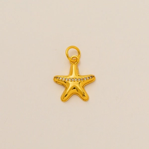 Minimalist gold starfish pendant with white zirconia accents on beige background