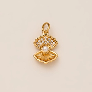 Détail d'un pendentif coquillage plaqué or 18K avec zircons brillants et perle blanche