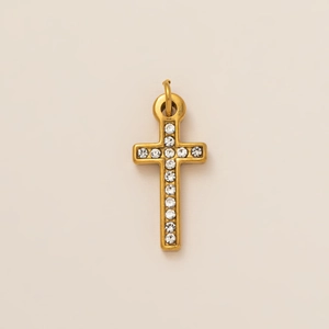 Detail shot of a vintage gold cross pendant featuring eleven inlaid clear zircons and matte finish