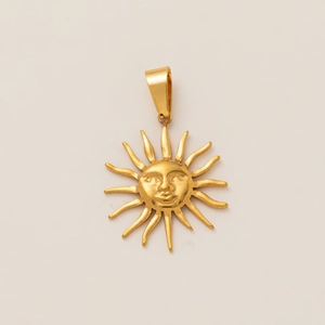 Detail of 18K gold-plated sun face pendant with wavy rays and polished metallic texture