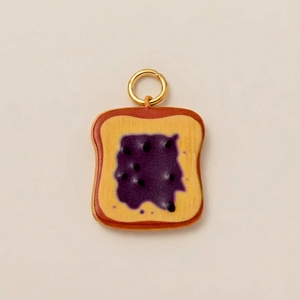 Detailed view of mini toast charm with purple jam and gold plated hanging ring