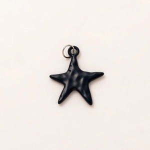 Detailed macro view of a matte black starfish pendant with textured resin finish
