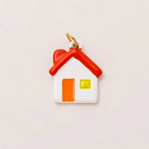 Macro shot of colorful house charm with gold ring and smooth enamel finish detail