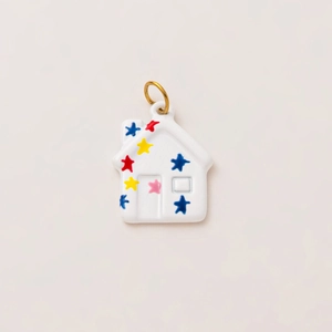 Close-up of house-shaped flower pendant with colorful stars and 18K gold ring