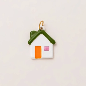 Detail of a 18K gold plated house pendant with green roof and colorful enamel finish
