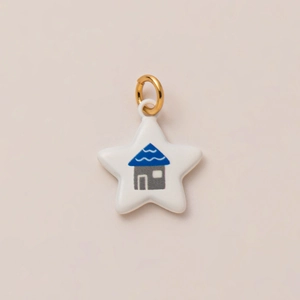 Primer plano de un colgante de estrella con motivo de casa y anillo dorado para joyería