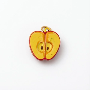 Détail du pendentif en émail en forme de pomme avec noyau et anneau doré poli