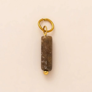 Macro detail of vintage brown stone pendant with white spots and gold rings
