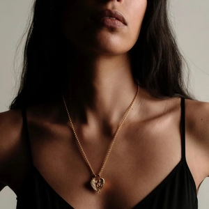 Collier avec pendentif ange en or 18 carats porté par une femme sur la clavicule
