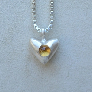 Detailansicht der herzförmigen Silberkette mit gelbem Edelstein und Box-Kette