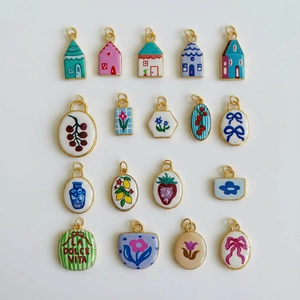 Detailopname van geëmailleerde hangers met vintage bloemmotieven en huisvormen