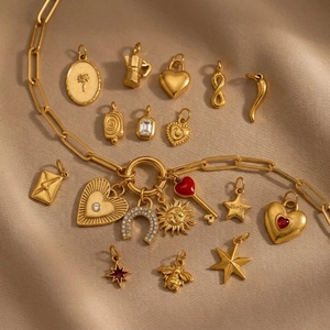 Gold plated necklaces with sun star and horseshoe charms on brown silk background