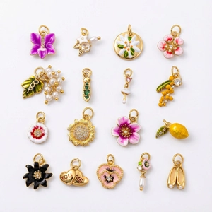 Vue détaillée de breloques plaquées or 18 carats aux motifs floraux et fruités en émail