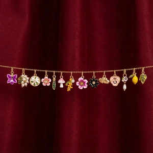 Collier doré 18K orné de 15 charms colorés fruits et fleurs sur fond de velours rouge