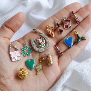 Emaille-Anhänger-Set mit rosa Tasche und Gänseblümchen in der Hand präsentiert