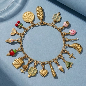Detail eines goldenen Bettelarmbands mit bunten Emaille-Anhängern und Mom-Herzgravur