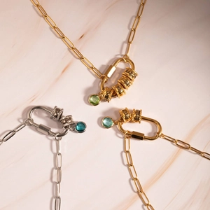 Detail van de 18K gouden geboortesteen ketting met paperclip schakels en gegraveerde kralen