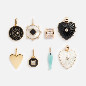Vue macro de divers pendentifs vintage avec motifs de cœur, de poisson et de zodiaque