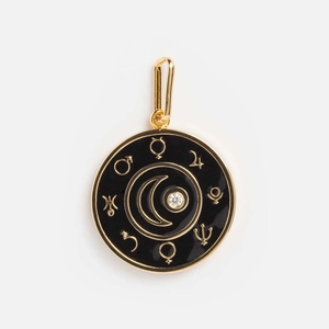Détail d'un pendentif vintage en or avec émail noir, croissant de lune et signes astrologiques