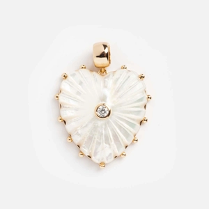 Gros plan du pendentif cœur doré avec nacre blanche et textures rayonnantes fines