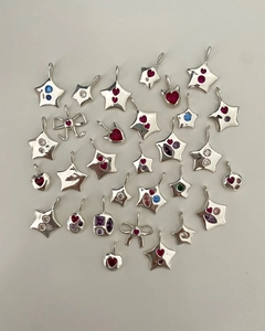 Macro shot of colorful zircon pendants with heart and star shapes in silver titanium steel
