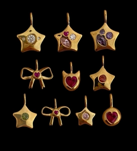 Detail of diverse gold titanium steel pendants with colorful zircon in heart and star shapes