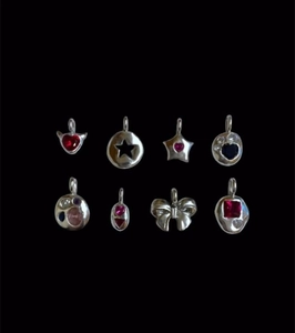 Close-up of 8-piece vintage silver charm set with colorful zircons and hearts
