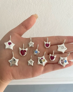Detail of colorful zircon star and heart pendants in titanium steel with 18k gold finish