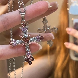 Detailed close-up of Gothic cross pendant with colorful rhinestones and silver chain