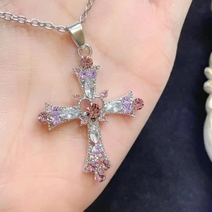 Detail of silver gothic cross pendant featuring pink crystals and heavy rhinestone inlay