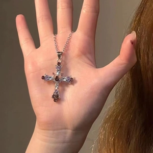 Detailed macro view of silver gothic cross pendant with colorful rhinestone inlay