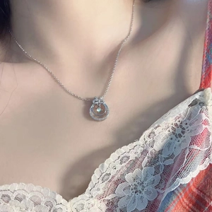 Elegant silver moonstone wreath bow necklace on female neck with a vintage plaid dress