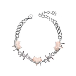 Close-up of silver Cuban chain with pink hearts and metallic wire wrap detail