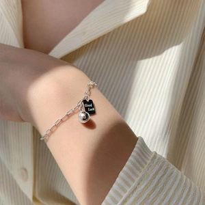 Detalle del collar de acero de titanio con colgante cuadrado y texto Good Luck