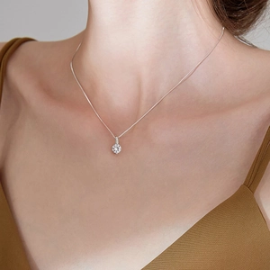 Détail d'un collier minimaliste avec un pendentif rond brillant en oxyde de zirconium